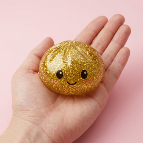 Gold Glitter Dumpling Squishy held in hand, actual size
