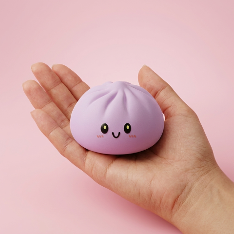 Grey & Magenta Dumpling Squishy held in hand, actual size