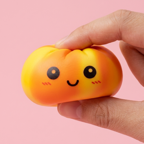 Tie Dye Orange Dumpling Squishy being squeezed, soft slow-rise foam