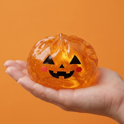 Light-Up Pumpkin Halloween Dumpling Squishy held in hand, actual size