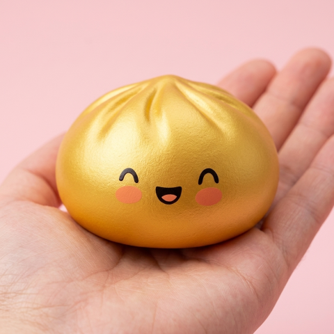 Lucky Gold Dumpling Squishy held in hand, actual size