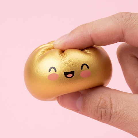 Lucky Gold Dumpling Squishy being squeezed, soft slow-rise foam