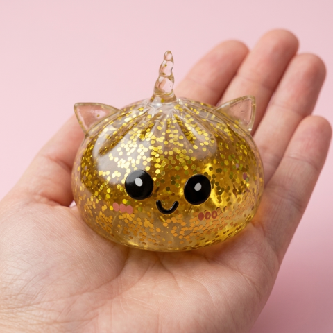 Gold Unicorn Glitter Dumpling Squishy held in hand, actual size