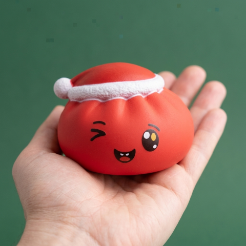 Red Christmas Hat Dumpling Squishy held in hand, actual size